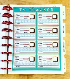 a tv tracker book sitting on top of a wooden table