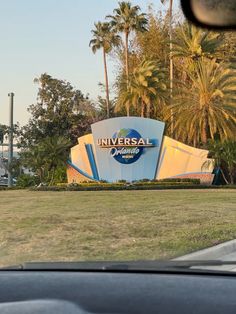 the sign for universal studios is shown in front of palm trees and other tropical vegetation