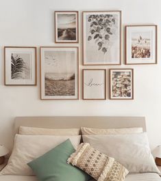 a bed with pillows and pictures on the wall above it