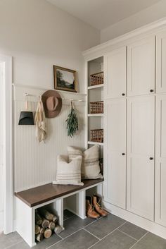 a mud room with shoes and hats on the shelves