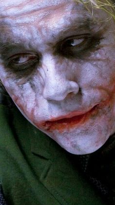 a close up of a person with makeup on and his face painted like the joker