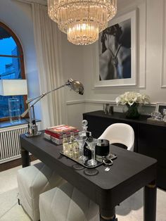 a dining room table with drinks on it and a chandelier hanging from the ceiling