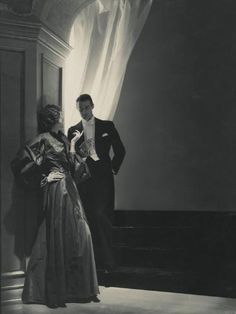 an old black and white photo of a man and woman standing next to each other