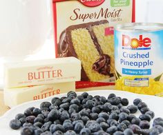 blueberries, butter, and other ingredients are on a plate next to a can of cake mix