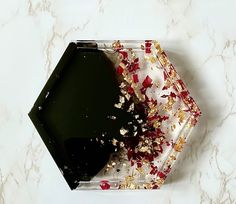 a black and gold plate with confetti sprinkles on the side