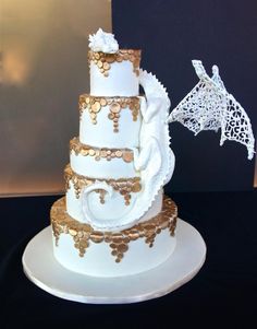 a white and gold wedding cake with a giraffe decoration