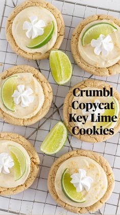 four cookies with lime cream frosting and two lime wedges on a cooling rack