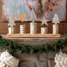 a mantle with christmas decorations and stockings on it, next to a painting that says merry