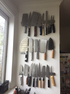 many knives are hanging up on the wall