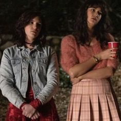 three young women standing next to each other with their arms crossed and one holding a coffee cup