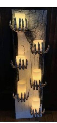 some candles are lit up in the shape of a tree with branches and birds on it