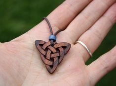 "This beautiful and unique hand-carved Triquetra pendant will be made for you, or a loved one, in my studio on the West of Ireland. This delicately carved Celtic knot features a piece of rosewood, recycled from musical instruments constructed by a local luthier. As a musician myself, I take enormous satisfaction in creating a piece of jewellery whose inherent wood has previously featured in a beautiful hand-made guitar! Celtic knots date back to the 3rd to 4th century B.C. They were used to symb Handmade Mahogany Jewelry Gift, Handmade Mahogany Jewelry For Gift, Mahogany Handmade Jewelry For Gift, Unique Mahogany Jewelry For Gift, Brown Carved Spiritual Jewelry, Traditional Mahogany Jewelry As Gift, Spiritual Brown Carved Jewelry, Traditional Mahogany Jewelry For Gifts, Symbolic Carved Brown Jewelry