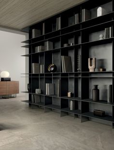 a large bookcase with many books on it in a room that has concrete floors