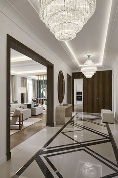 an elegant living room with chandelier and marble flooring in white, brown and black