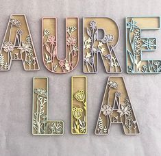 the letters are made out of wood and have floral designs on them, including flowers