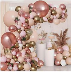 a bunch of balloons that are in the air with pink and gold decorations on them