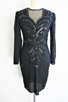 "This is a striking black beaded silk dress.   It is in good vintage condition, but is missing a few barrel beads on the back (see pic). Marked size 2Petite 34\" bust 28\" waist 34\" hip 35\" nape to hem  Purveyor's Note: We have searched far and wide, wrestled bears, braved the cold, traversed mountain ranges, fought pirates, swam with sharks and eaten at many a questionable road side taco stand to provide our customers with one of a kind vintage pieces.  Know that whichever piece you choose to make your own has its own story and has traveled through time to get to you.  Though we strive to provide the absolute best, \"pristine\" vintage pieces are rare birds, if not altogether non-existent.  That being said, please understand that part of buying and wearing vintage is accepting some of t Taco Stand, Mountain Ranges, Beaded Cocktail Dress, Rare Birds, Dress Silk, Vintage Pieces, Sharks, Dress Clothes For Women, Black Beads