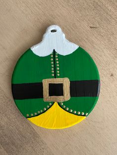 a green and yellow christmas ornament hanging on a wall