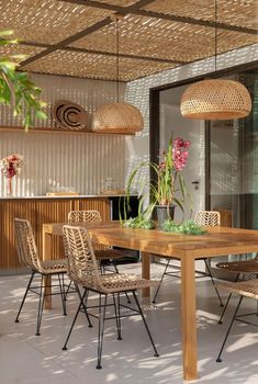 an outdoor dining area with wicker chairs and wooden table surrounded by hanging bamboo lights