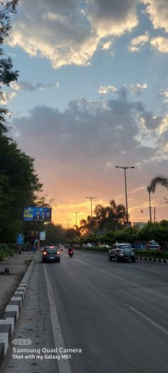 cars are driving down the street at sunset