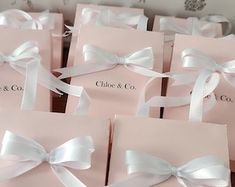 many pink boxes with white bows on them