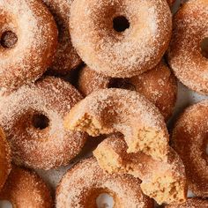 a pile of sugared donuts with holes in the middle and powdered on top