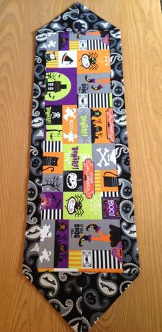 a neck tie is decorated with halloween images and designs on it's black, gray, orange, and green color scheme