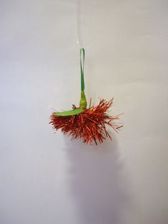 an orange and green object hanging from a hook on a wall in a room with white walls