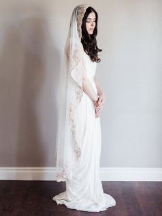 a woman in a wedding dress is standing on the floor with her veil over her head