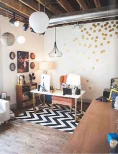 a living room filled with lots of furniture next to a white wall covered in gold polka dots