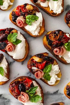 several pieces of bread with various toppings on them sitting on a marble counter top