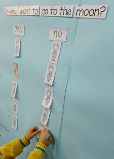 a child is writing on a bulletin board with the words do you want to go to the moon?