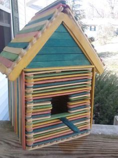 a bird house made out of strips of colored paper