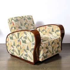 an upholstered chair sitting on top of a hard wood floor next to a wall