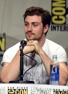 a man sitting at a table in front of a microphone