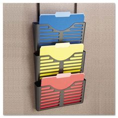 three folders are hanging on the wall in front of a bulletin board with two file holders attached to it