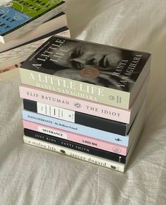 a stack of books sitting on top of a bed