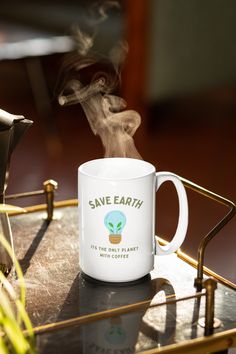 a white coffee mug with steam rising out of it sitting on top of a metal tray