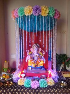 the ganeshi idol is decorated with flowers and beads on display in this room