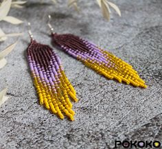 "These purple yellow beaded earrings pair amazingly with any outfit, dressy or casual. They will emphasize your individuality and compliment your personality on various occasions. Perfect for looking pulled together and on trend. They are made of high-quality Czech colored beads with sterling silver hooks and silicone plugs. Colors: shining purple, purple, shining yellow, yellow. Length: 4 inches (10.5 cm) Width: 0.8 inches (2 cm) Materials:     Czech \"Preciosa\" beads     Durable synthetic thread     Sterling silver ear hooks     Silicone plugs If you are on the hunt for a gift that will show your significant other some love, these picks are a great solution to surprise and delight. I hope you can find everything here that you were looking for. If you have any questions related to earrin Yellow Beaded Dangle Chandelier Earrings, Yellow Beaded Earrings With Gold Round Beads, Yellow Gold Beads Drop Earrings, Yellow Gold Beaded Drop Earrings, Yellow Gold Beaded Round Earrings, Yellow Beaded Fringe Earrings With Round Beads, Yellow Beaded Earrings With Dangling Round Beads, Yellow Beaded Drop Earrings With Dangling Beads, Yellow Beaded Fringe Drop Earrings