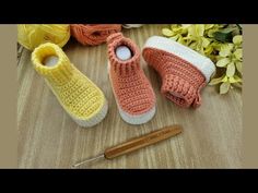 three crocheted slippers sitting on top of a wooden table next to yarn