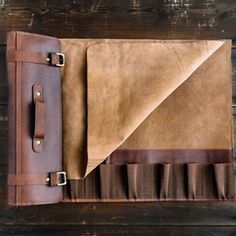 a brown leather case sitting on top of a wooden table