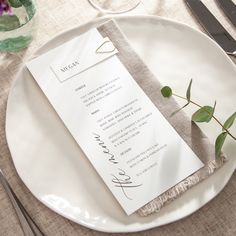 a white plate with a menu and silverware on it, along with utensils