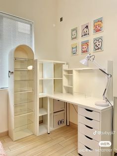 a white desk with drawers and a lamp on top of it next to a window