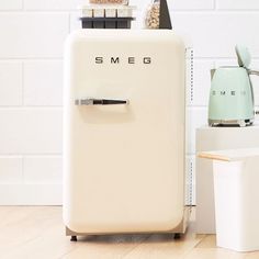 a white refrigerator sitting next to a toaster oven on top of a wooden floor