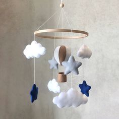 a baby crib mobile with clouds and stars hanging from it's sides,