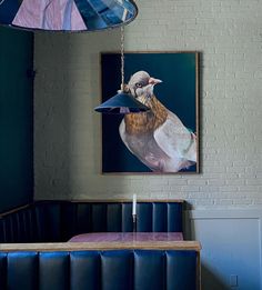 a bird is hanging from the ceiling in a restaurant with blue booths and purple upholstered chairs