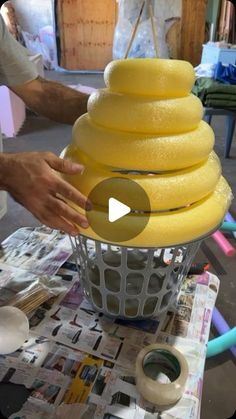 a person is making a cake with yellow icing