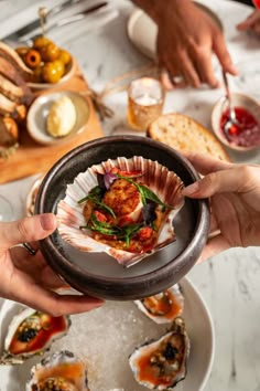 several people are holding small plates with food on them and serving them to each other