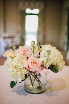 a vase filled with white and pink flowers on top of a table